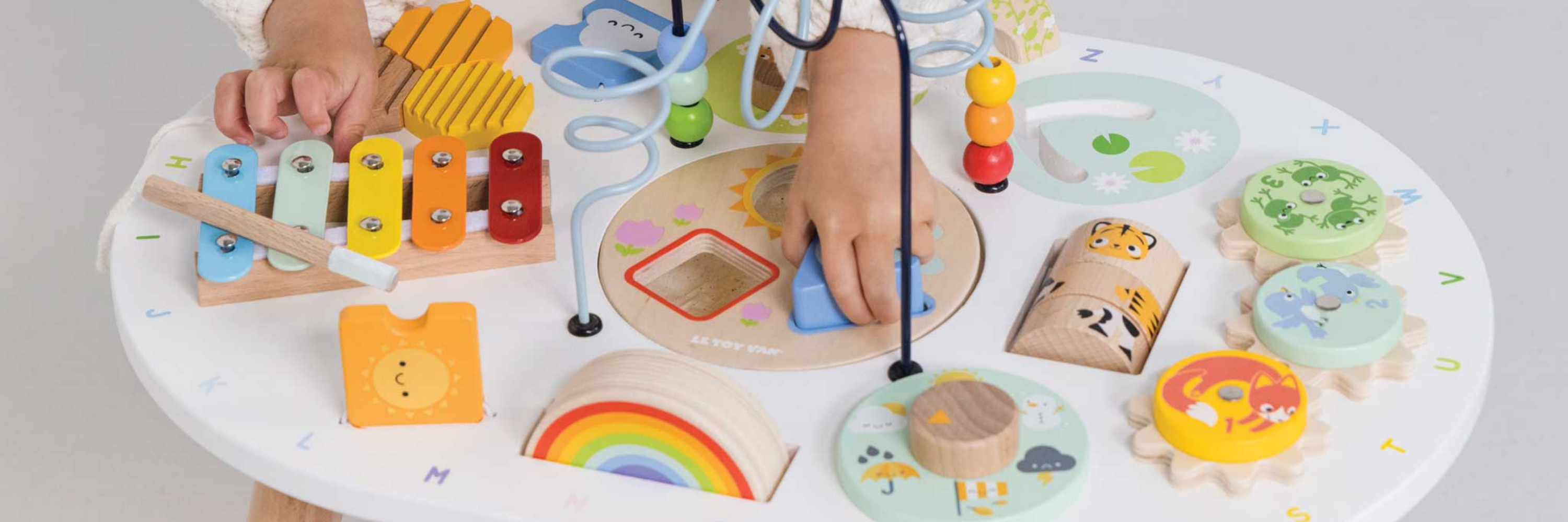 Children's play area with various educational toys on a round white table.