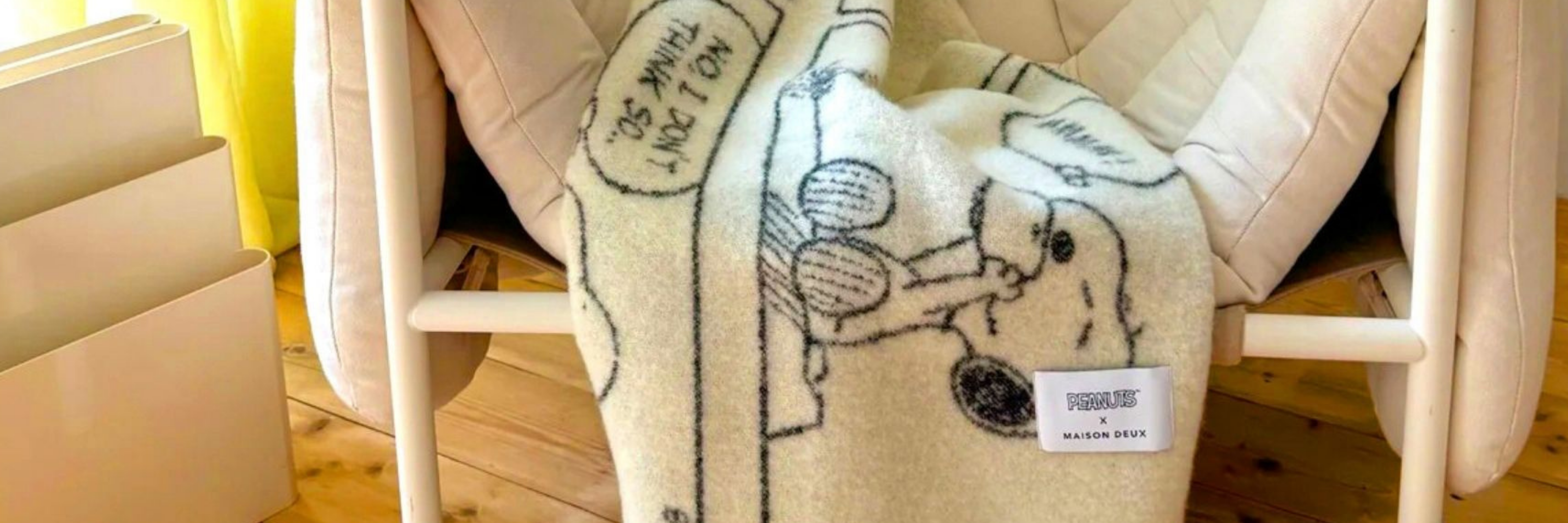 Blanket with cartoon design draped over a chair, with boxes in the background