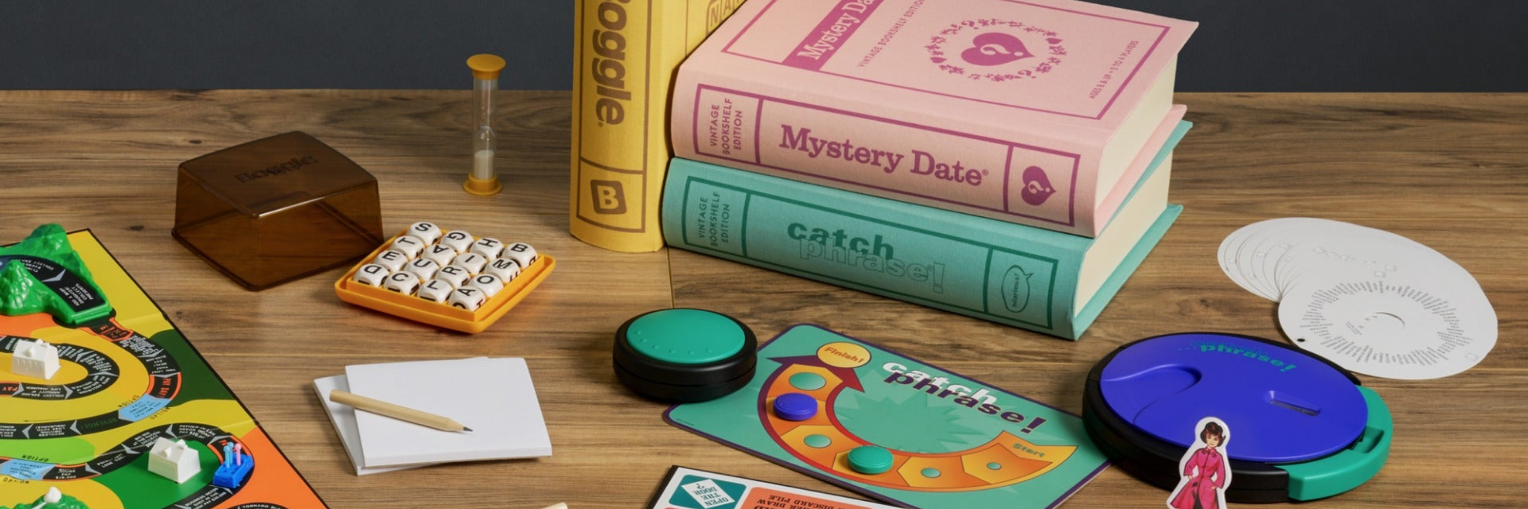 Board game components on a wooden table with books in the background
