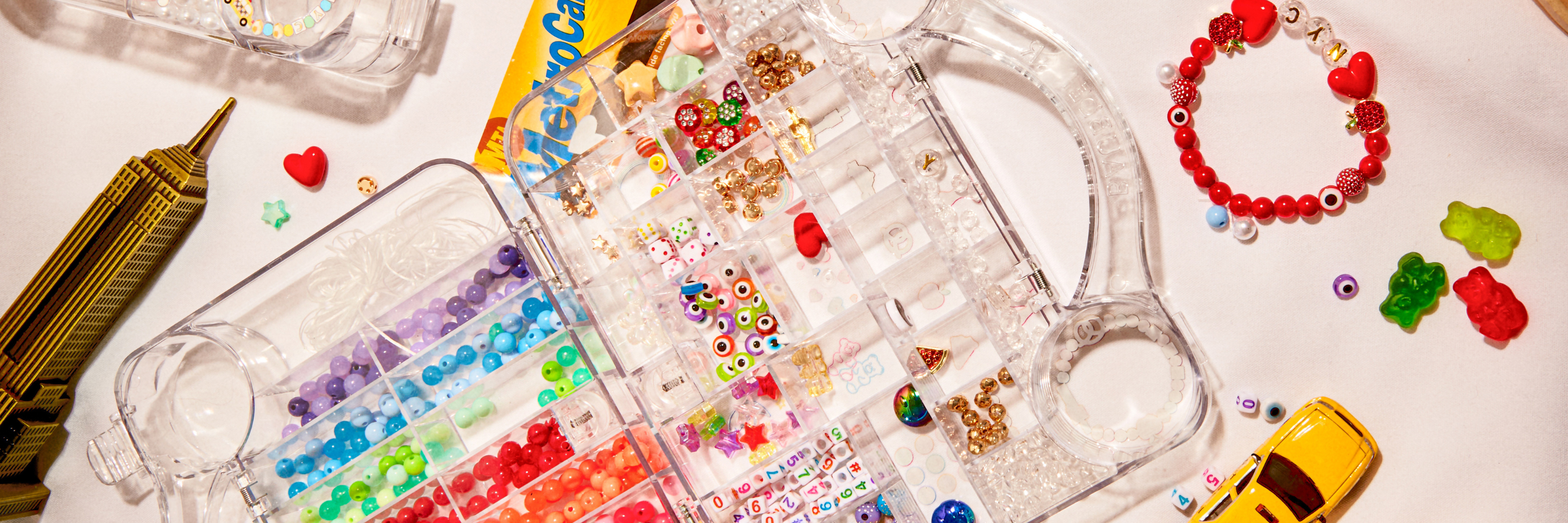 Clear plastic mold with colorful beads and small toys on a white background