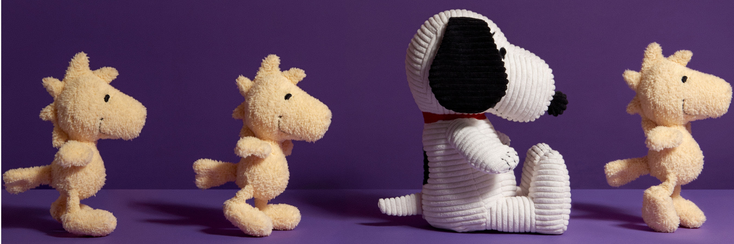 Four knitted dog toys on a purple background