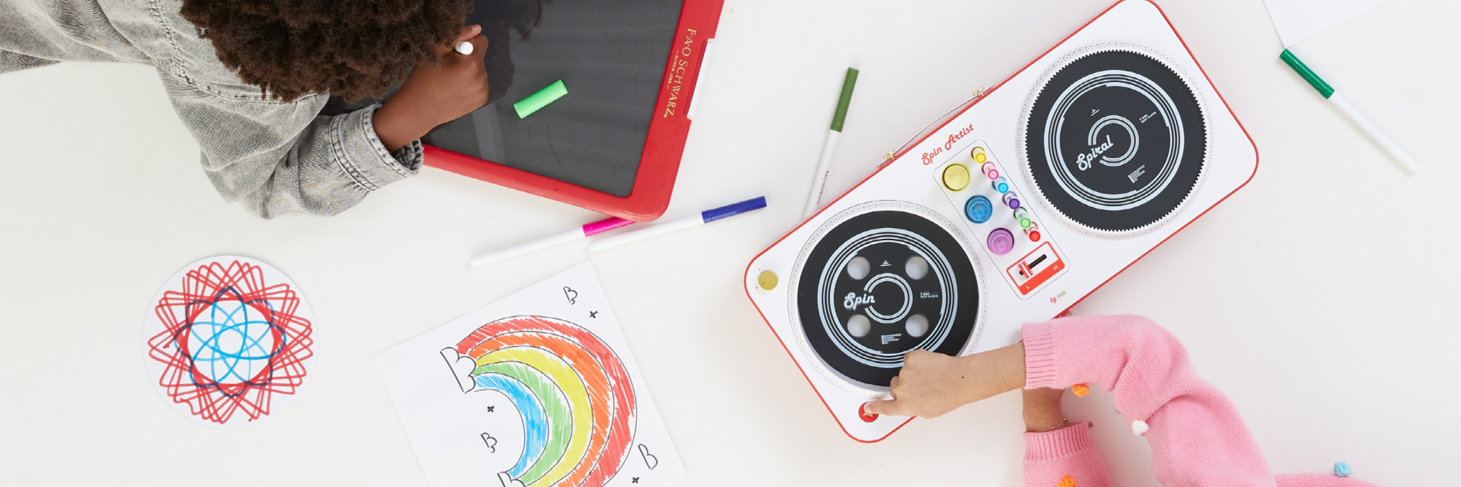 Children playing with a toy music console and drawing on paper