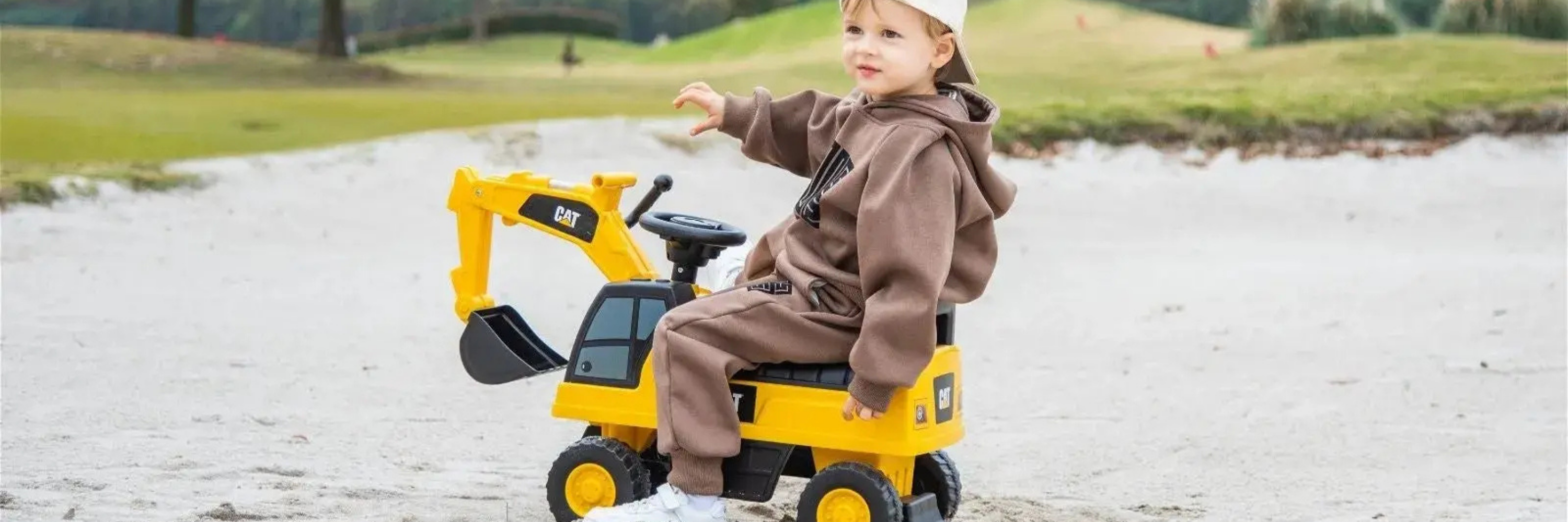 Child playing with a toy excavator in an outdoor setting