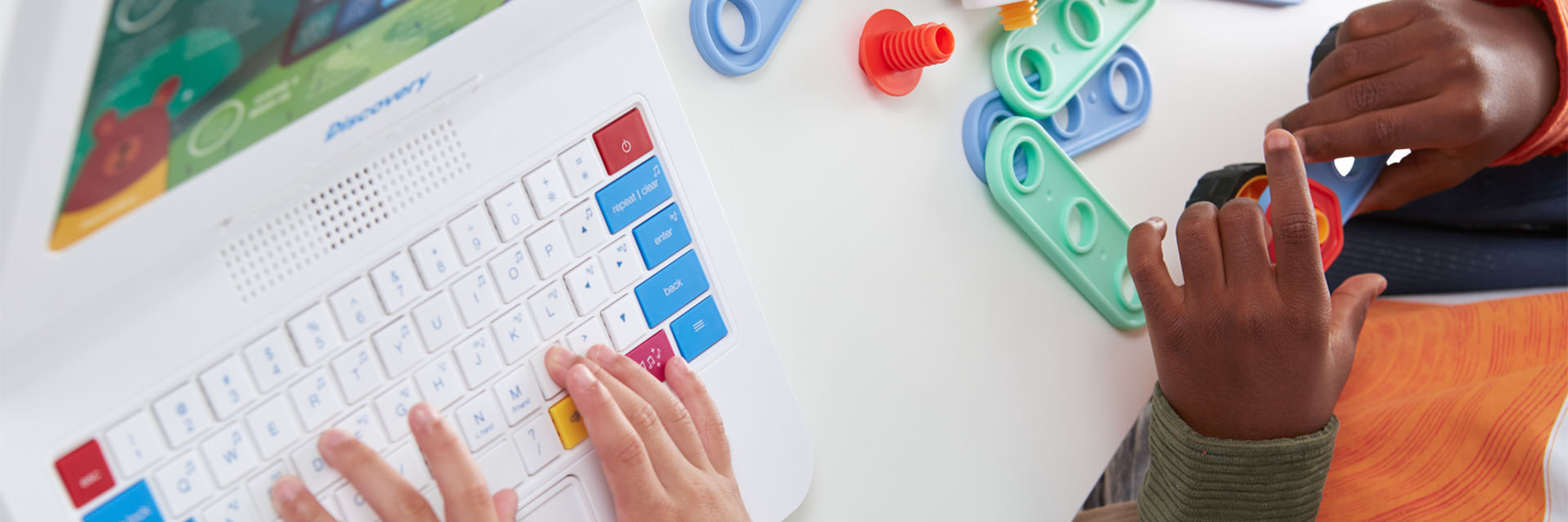 Children playing with a toy keyboard and colorful building blocks on a desk.