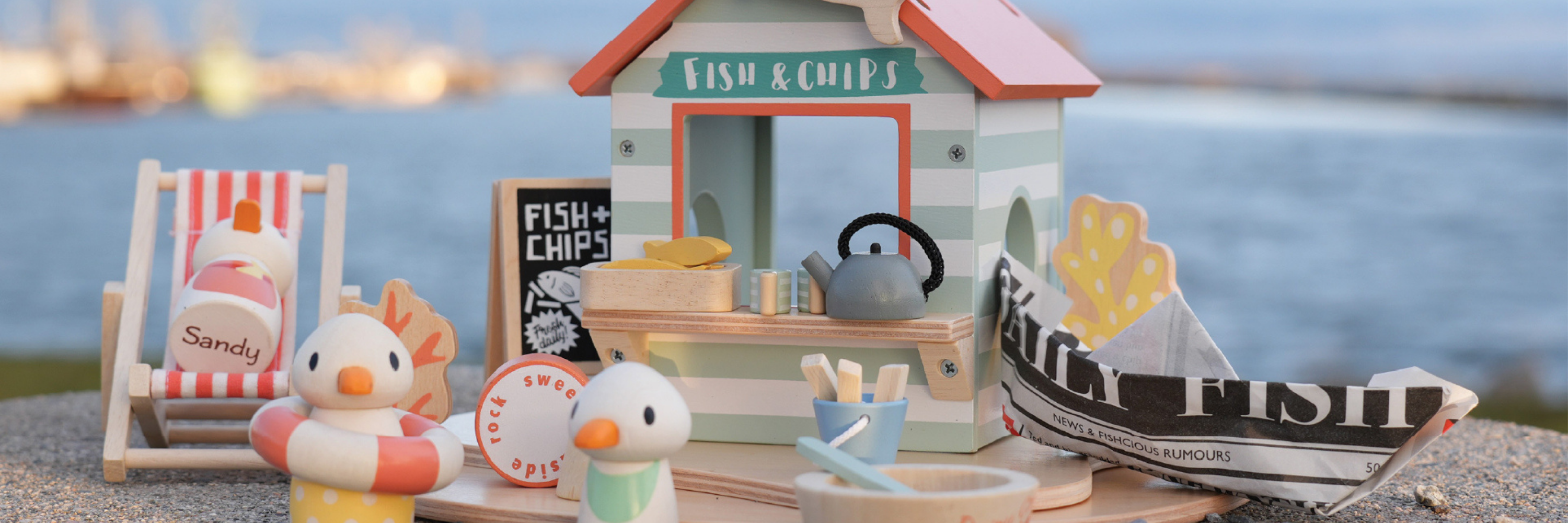 Toy fish and chip shop with ducks and a boat on a beach setting