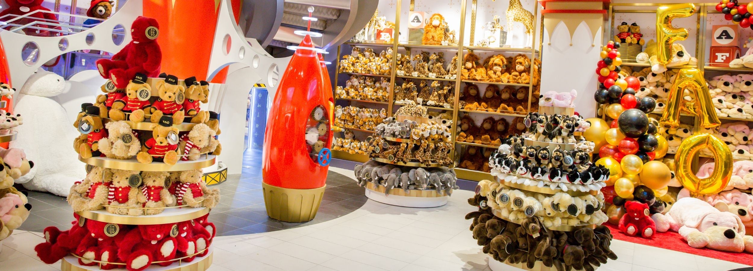 Decorative items including a cake-like structure with red and white polka dots, a tall red and white object, and various small figures on a white surface.