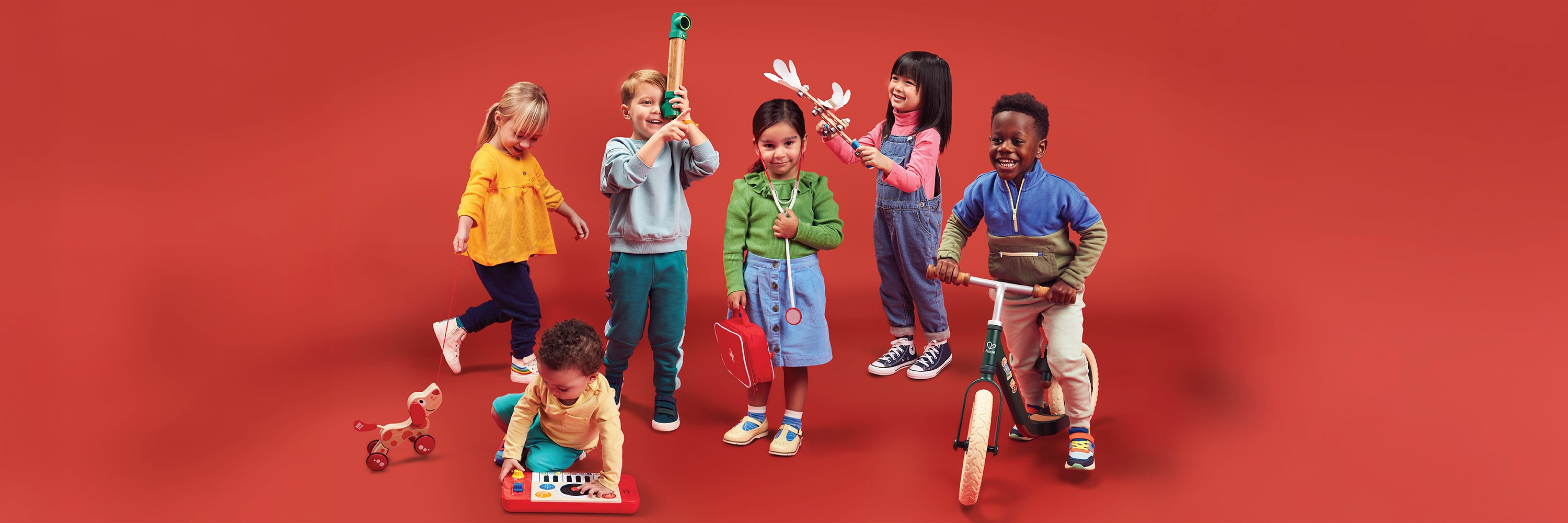 Children playing with toys on a red background