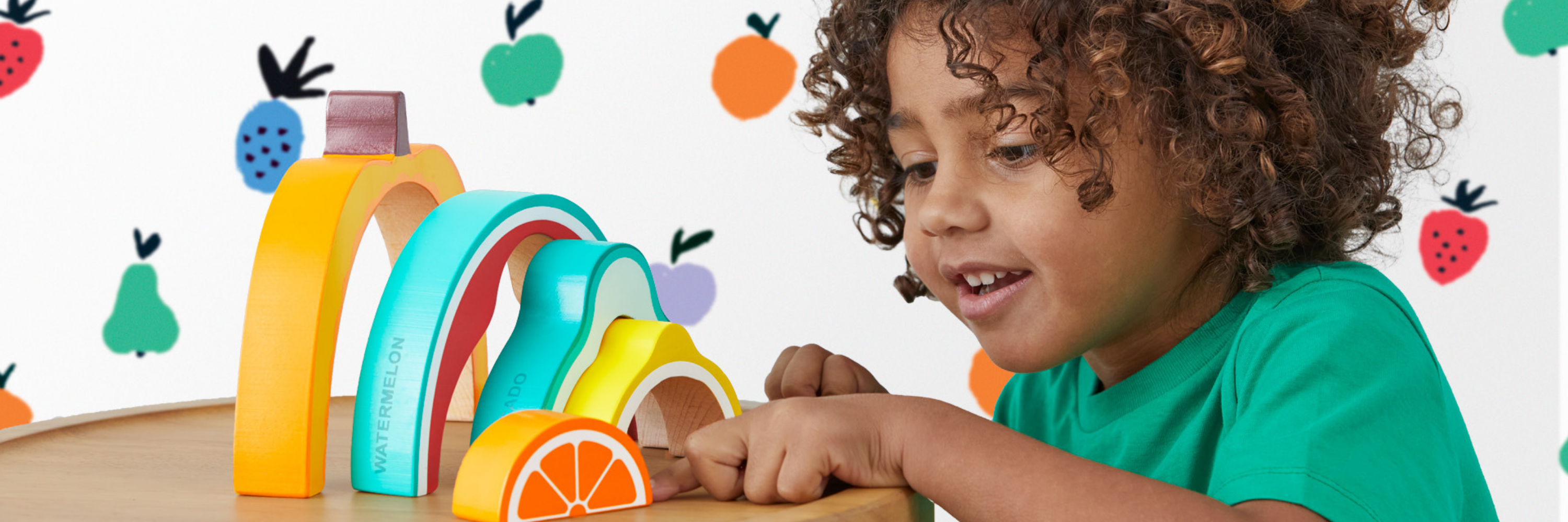 Child playing with colorful wooden toys on a white background with fruit illustrations.