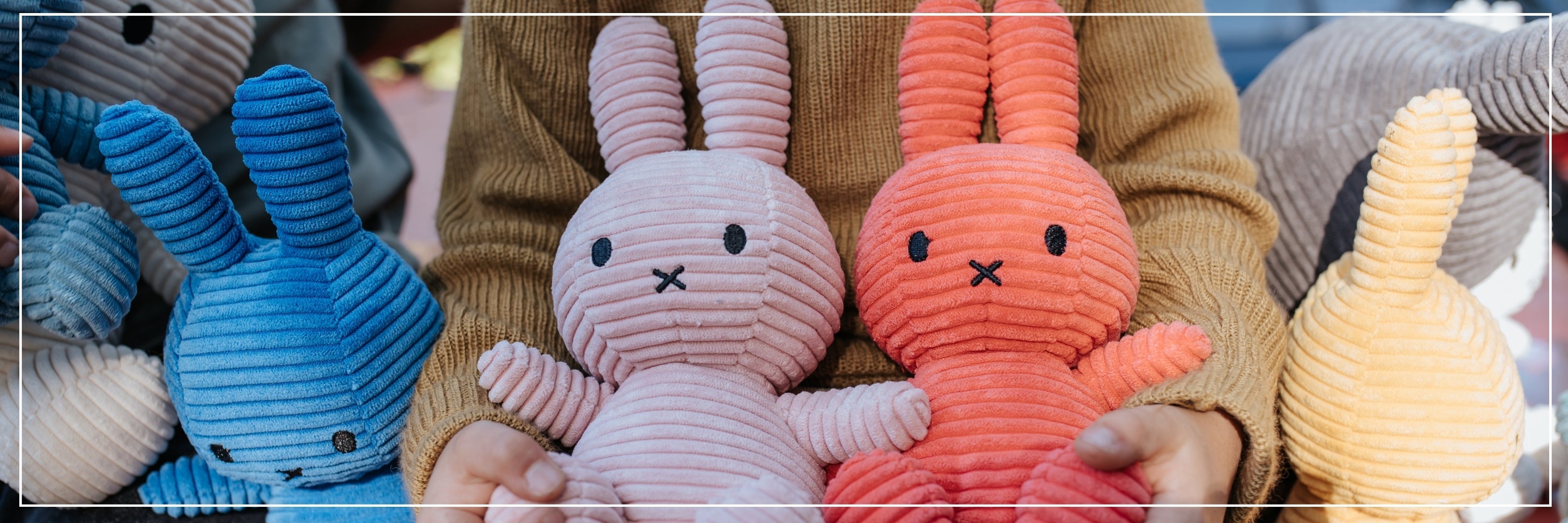 Collection of colorful ribbed bunny toys held by a person.