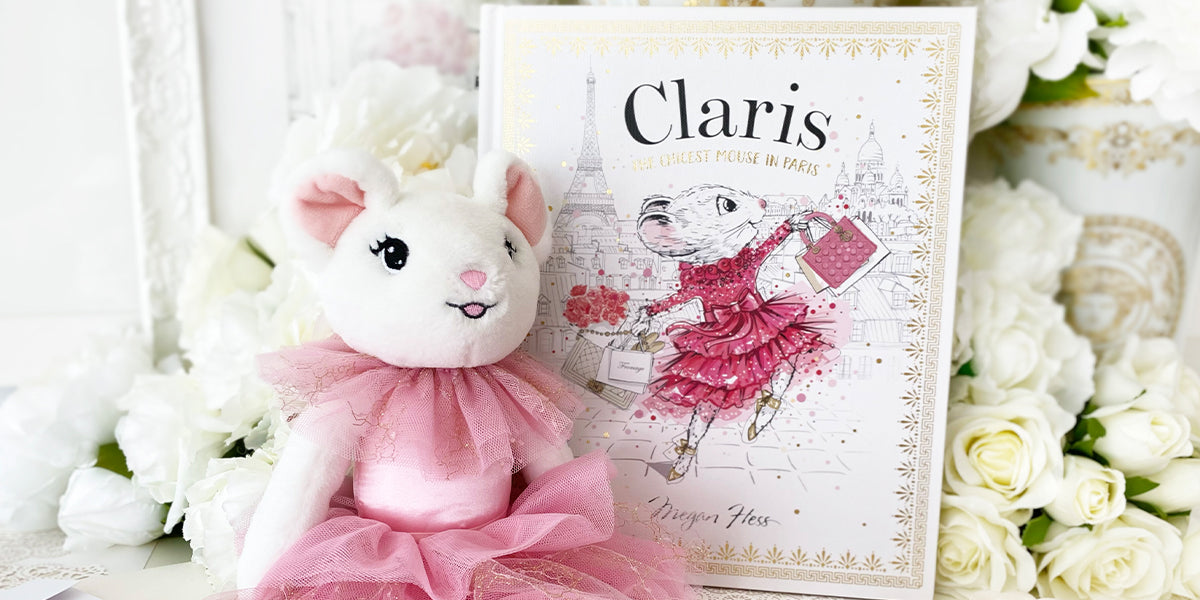 Plush toy rabbit in a pink dress next to a book titled 'Claris' on a floral background