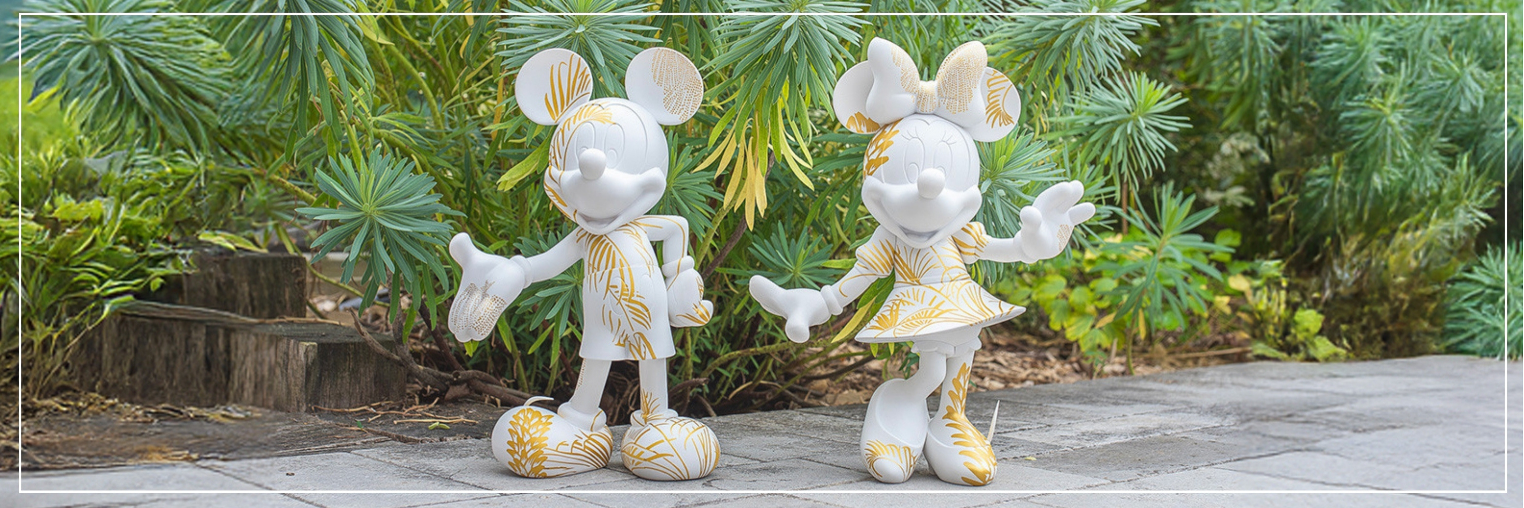 Two decorative statues of a cartoon character in a garden setting