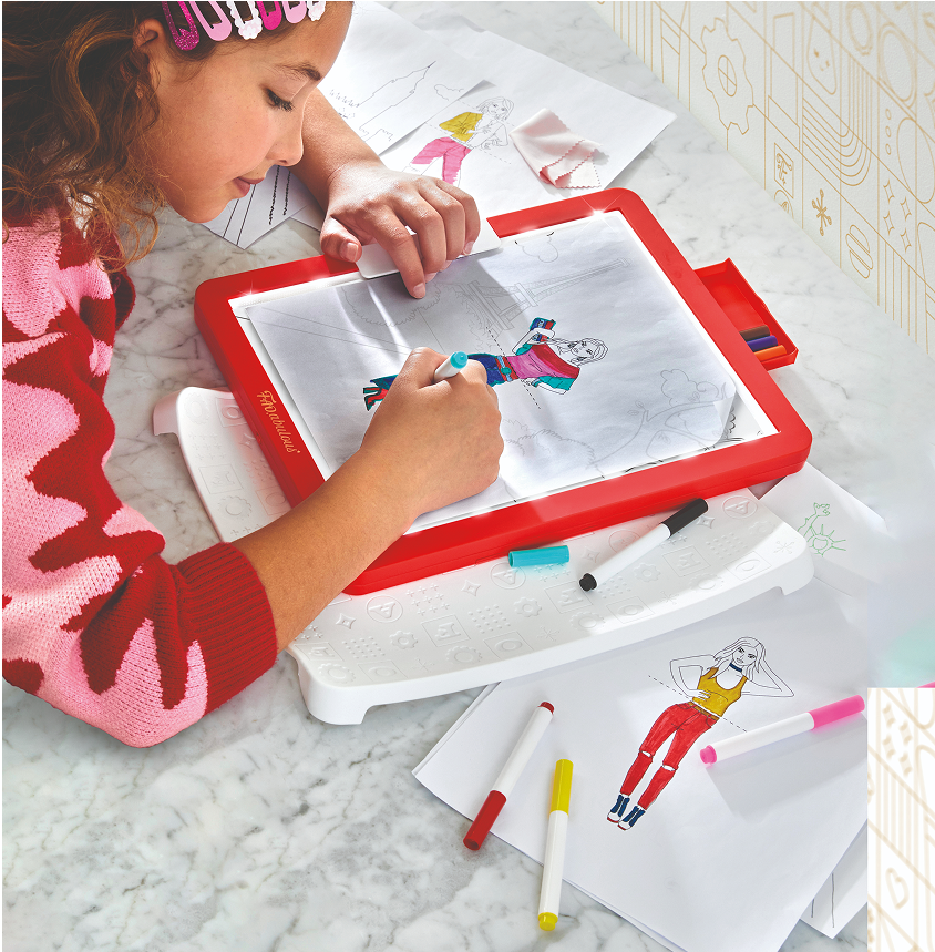 Child using a red and white drawing board with markers on a marble surface.