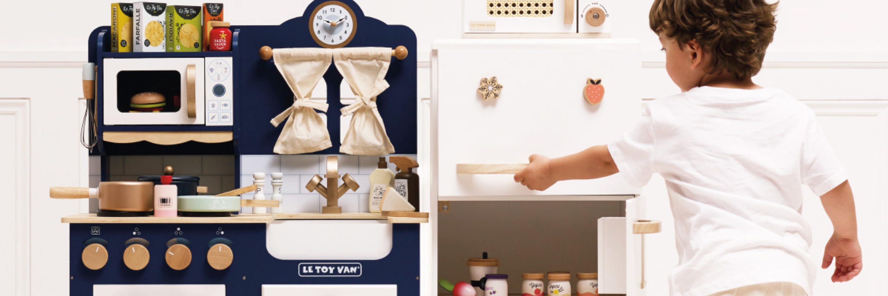 Child playing with a toy kitchen set in a kitchen setting