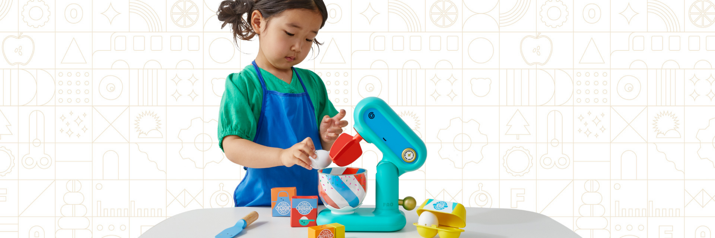 Child playing with a toy kitchen set on a white background