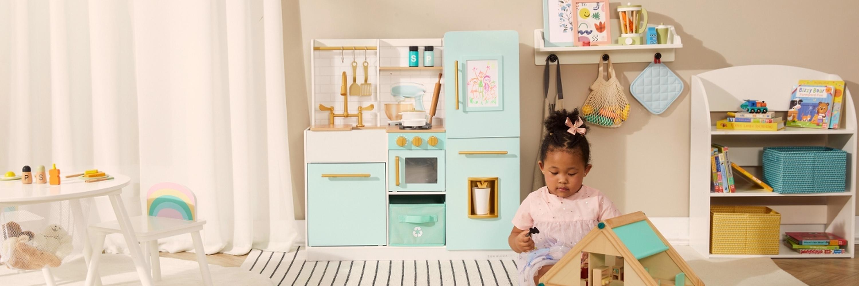 Child playing with a toy kitchen set in a bright room