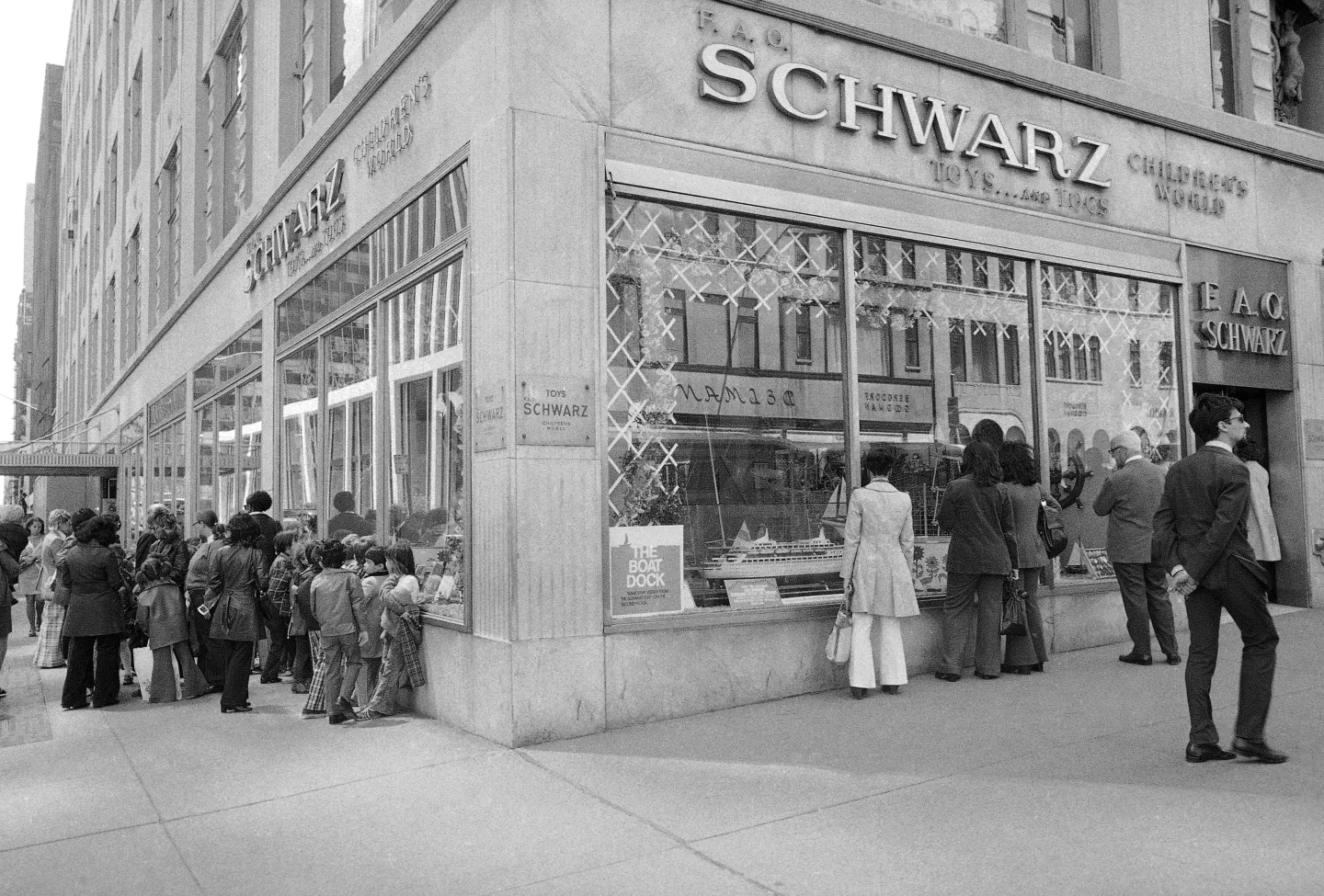 Vintage black and white photo of people outside a store with 'Schwarz' branding.