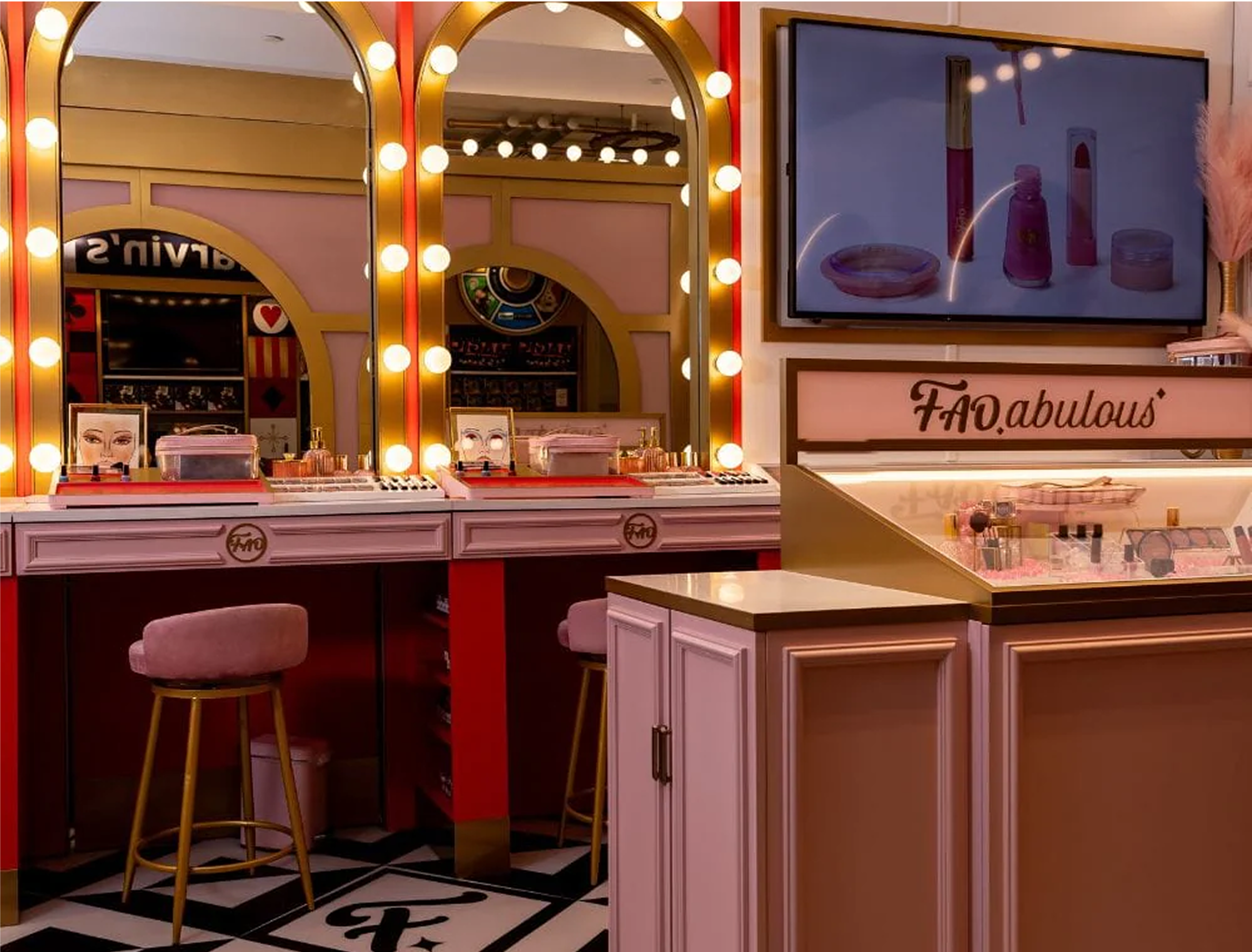 Makeup station with mirrors, products, and a TV screen displaying cosmetic items in a store.