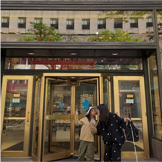 Two people standing outside a building with revolving doors.